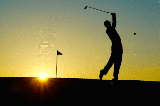 Golfeur en contre jour en plain swing